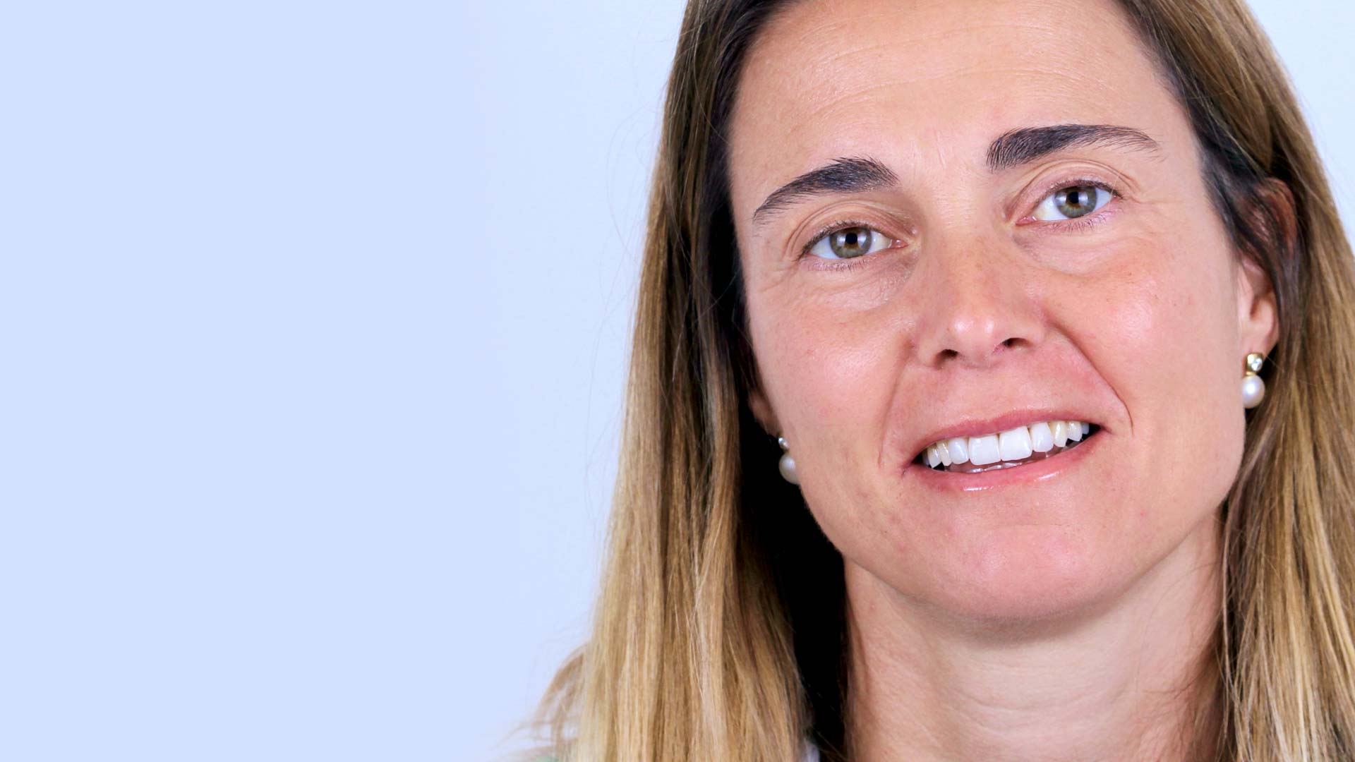 A woman smiles at the camera to show her new natural-looking beautiful smile.