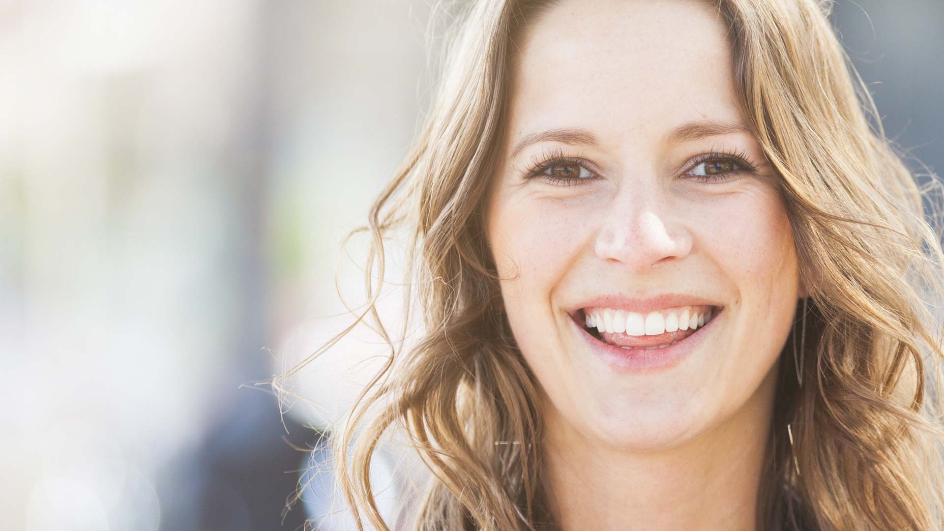 A close-up of a young woman showing her beautiful new smile