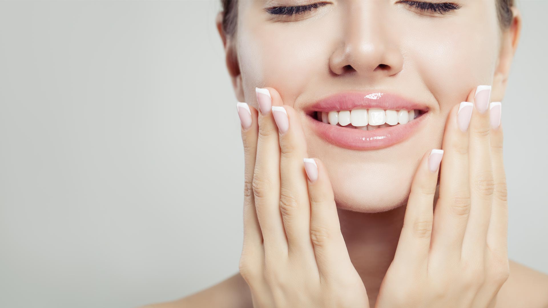 A close-up of a young woman with a beautiful white smile